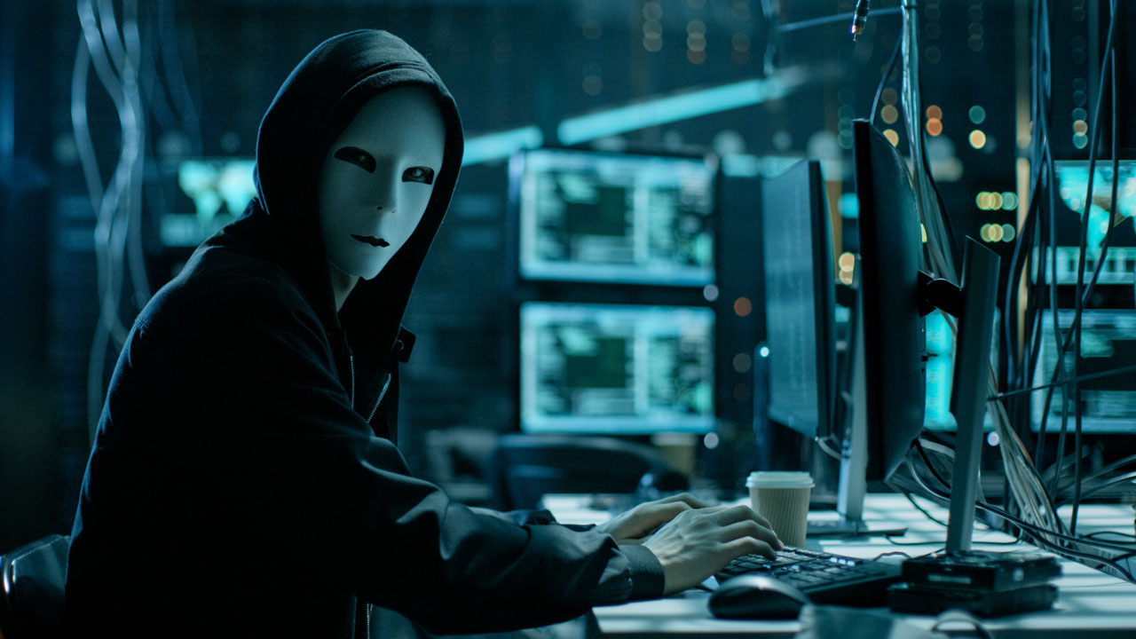 A hacker in a room of computers